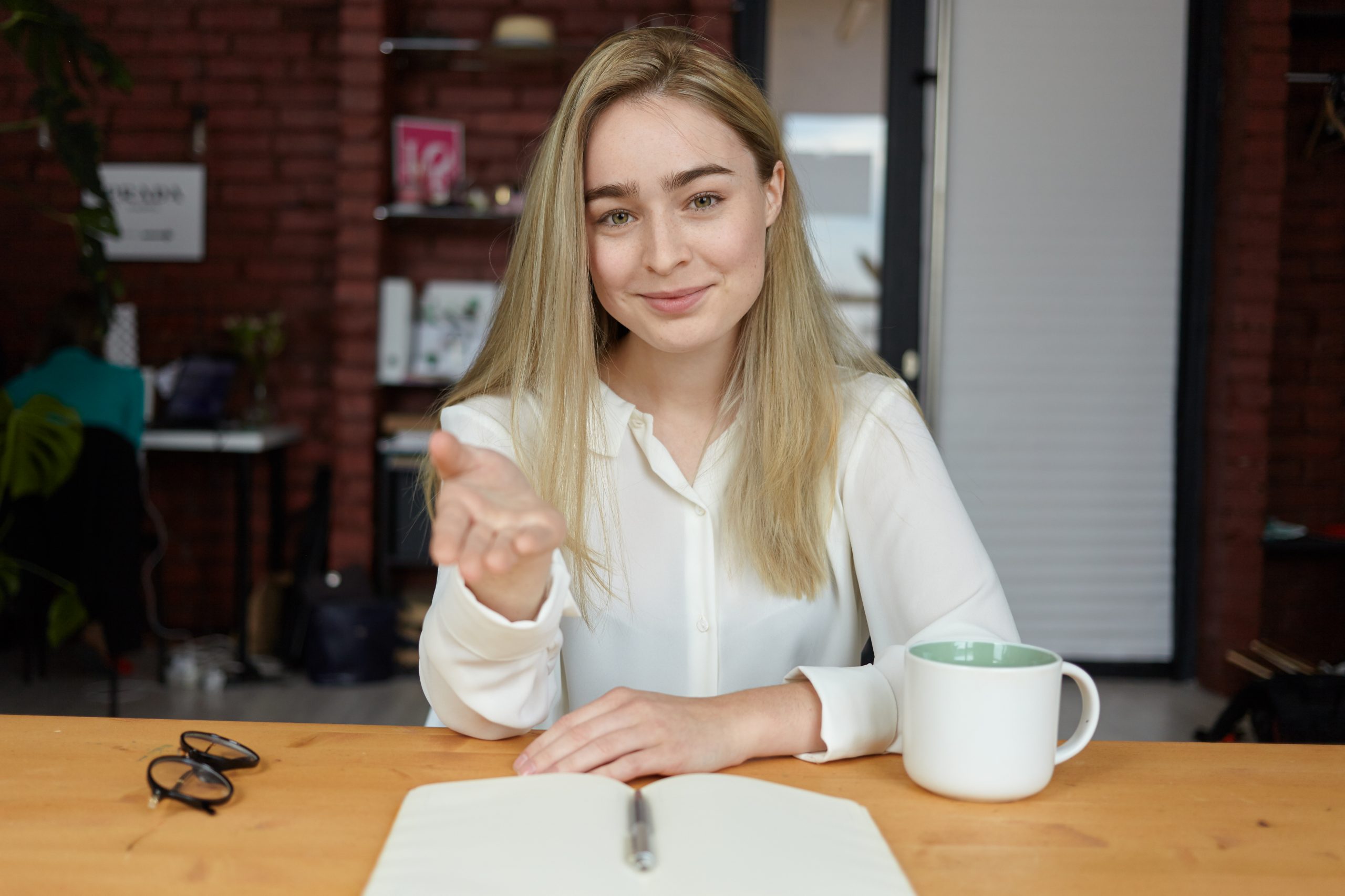 a woman sitting at a table with a cup of coffee | ask2axcel